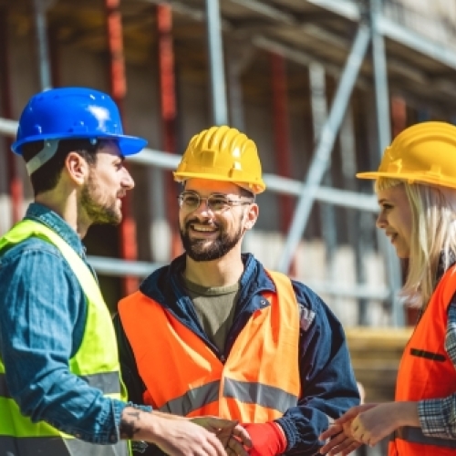 Erfarent entreprenørteam i dialog på byggeplads med fokus på kvalitet og samarbejde