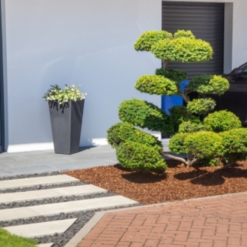 Udendørs belægning med fliser ved moderne indgangsparti og haveanlæg